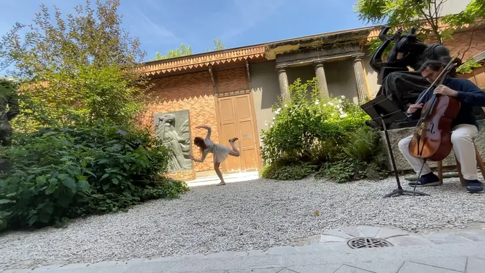Saut de la danseuse dans le jardin du musée, le violoncelliste au premier plan