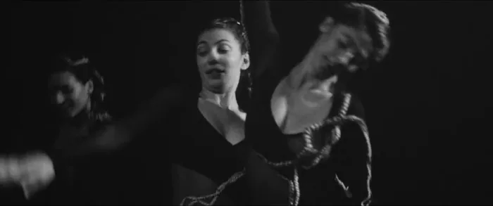 Le trio en mouvement, visages proches, dans l’obscurité