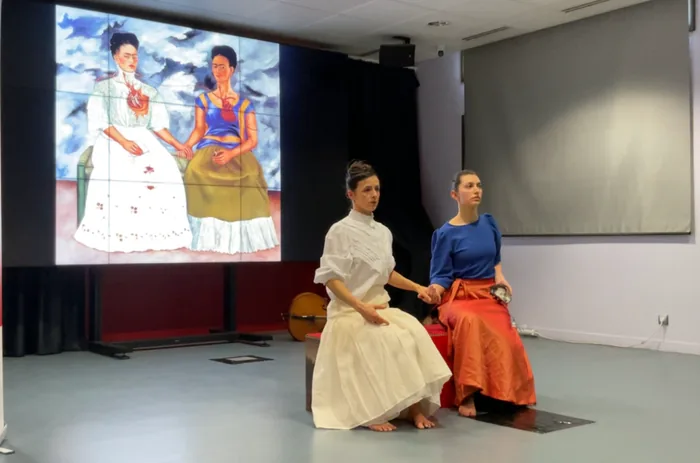 Les danseurs en costumes colorés devant l’écran du musée numérique